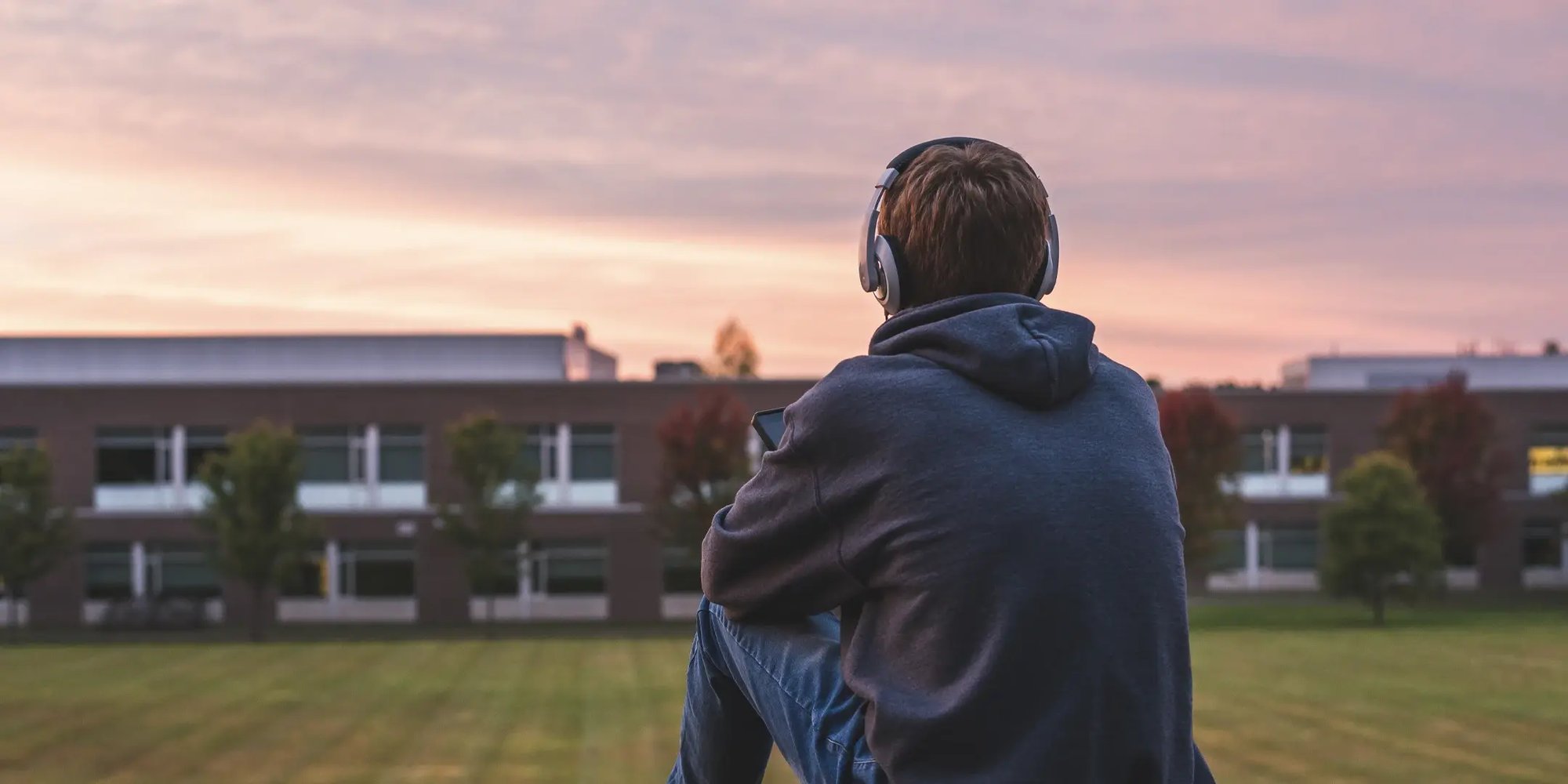 Student with headphones looking at the school